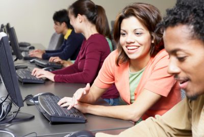 Group of students sitting in front of computer monitors